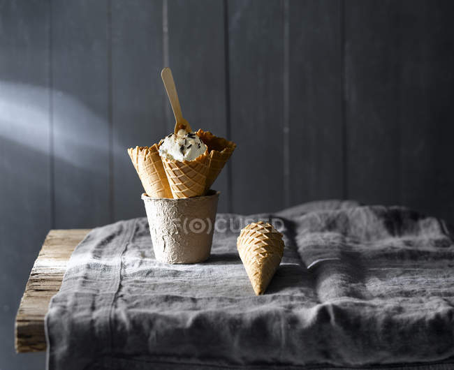 Ainda vida de cones de sorvete na caneca na mesa rústica — Fotografia de Stock