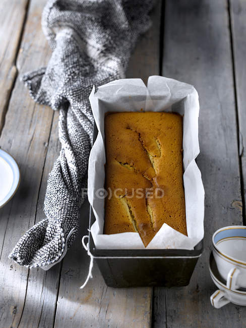 Baked pear cake in metal form with parchment on rustic gray table. — Stock Photo