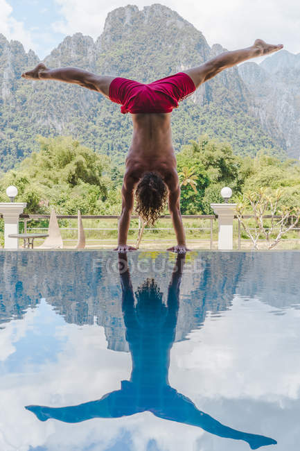Uomo in piedi su mani a piscina — Foto stock