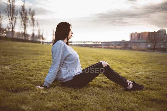 Жінка сидить на зеленій траві — стокове фото