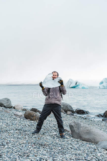 Homme tenant un morceau de glace — Photo de stock