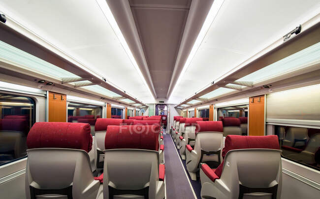 Cómodos asientos en el compartimiento de tren moderno que pasa por la campiña de invierno. - foto de stock
