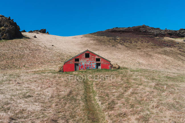 Casa roja en valle - foto de stock