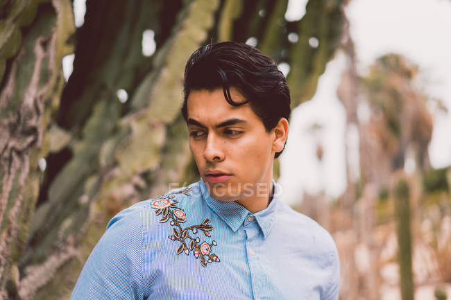 Mann steht an Kaktus im Garten — Stockfoto