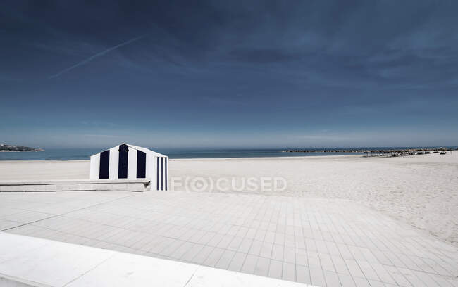 Vue à couper le souffle du ciel gris nuageux sur la plage vide avec du sable blanc. — Photo de stock