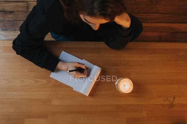Woman writing in notepad — Stock Photo