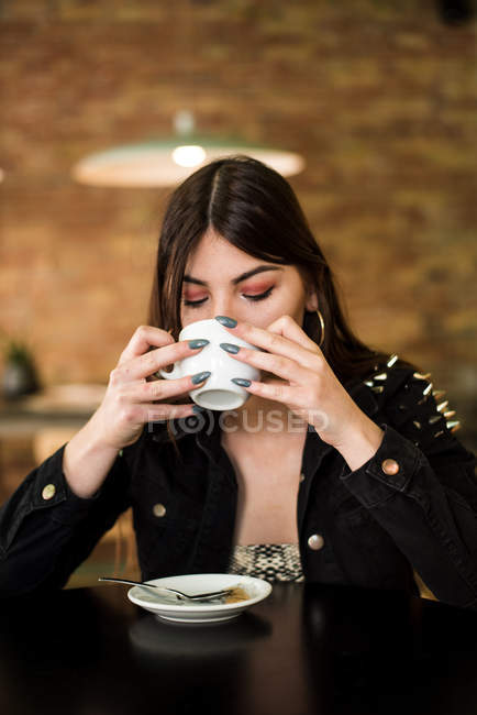 Женщина сидит в кафе с кофе — стоковое фото