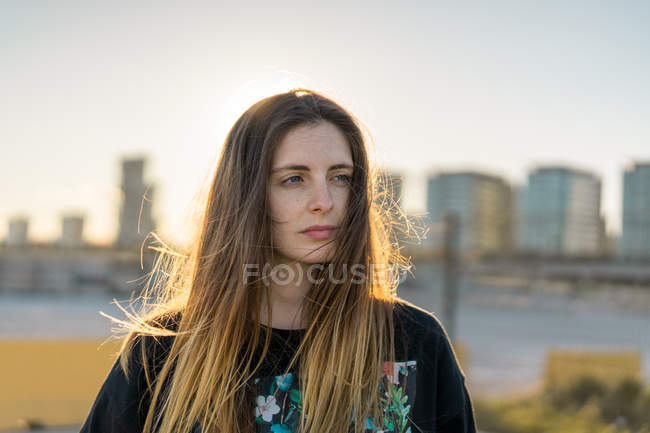 Frau steht in sonniger Stadt — Stockfoto