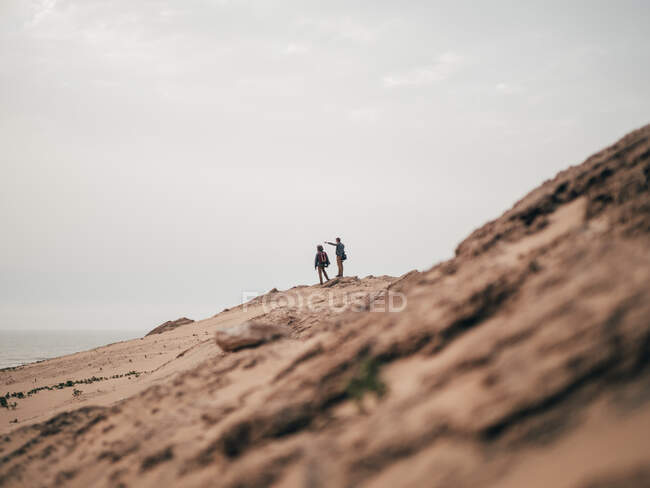 Туристы, стоящие на песчаном холме — стоковое фото