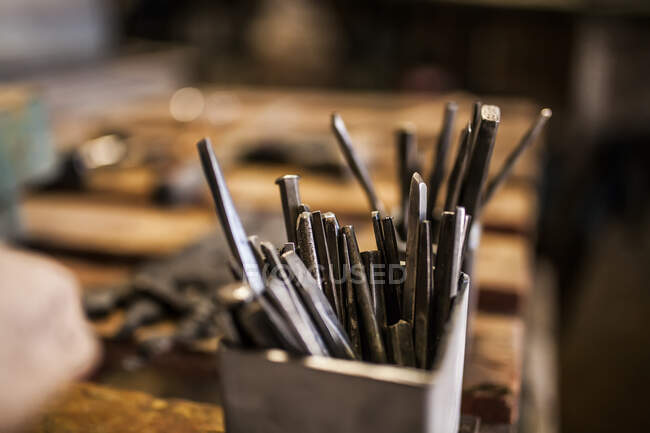 Vue en coupe du marteau et des instruments sur la table métallurgique en bois — Photo de stock