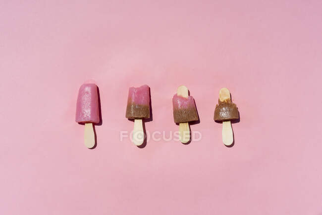 Popsicles lumineuses placées sur fond rose — Photo de stock