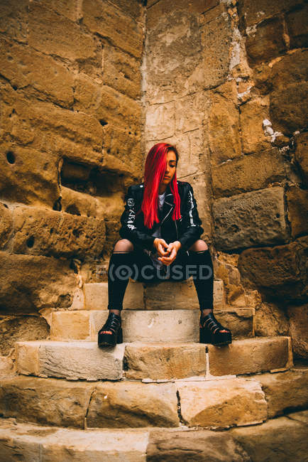 Frau im Rebellenkostüm sitzt auf Stufen — Stockfoto