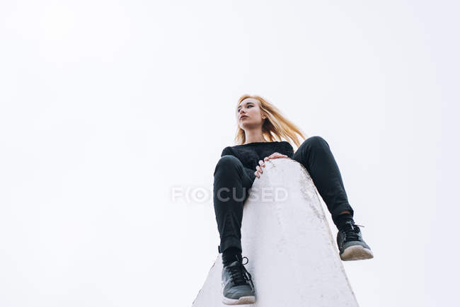 Frau sitzt auf Dachkante — Stockfoto