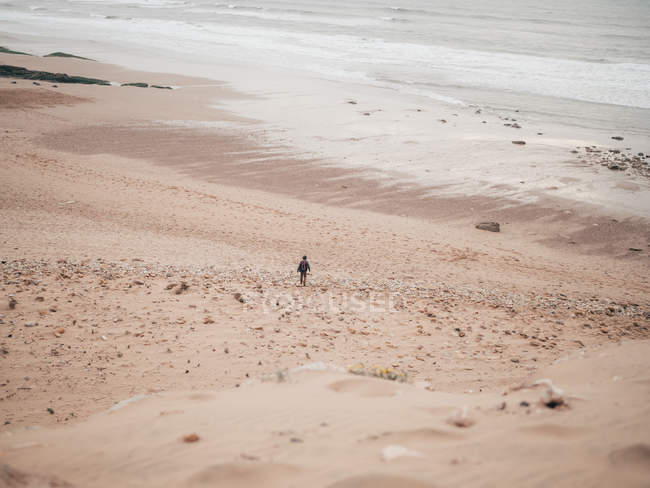 Турист, стоящий у спокойного океана — стоковое фото