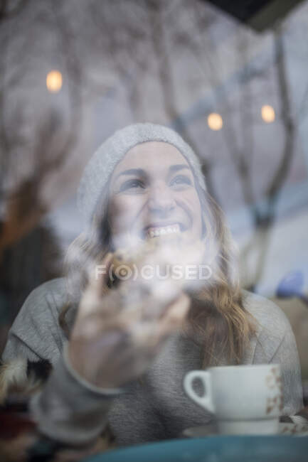 Mulher mordendo biscoito no café — Fotografia de Stock