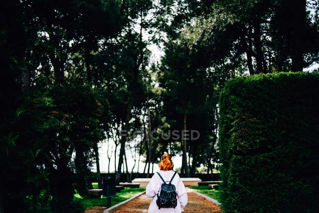 Femme avec sac à dos marchant en forêt — Photo de stock