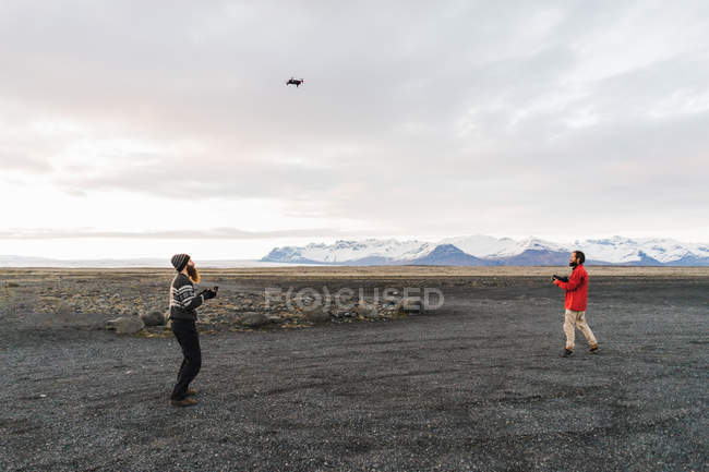 Hombres lanzando dron en valle - foto de stock