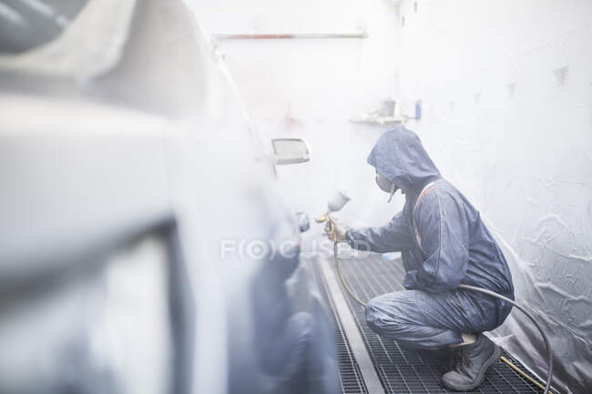 Painter posing in front of the booth before painting a car — Stock Photo