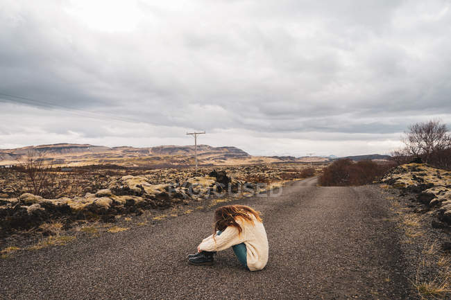Mulher sentada no caminho em natureza rochosa — Fotografia de Stock
