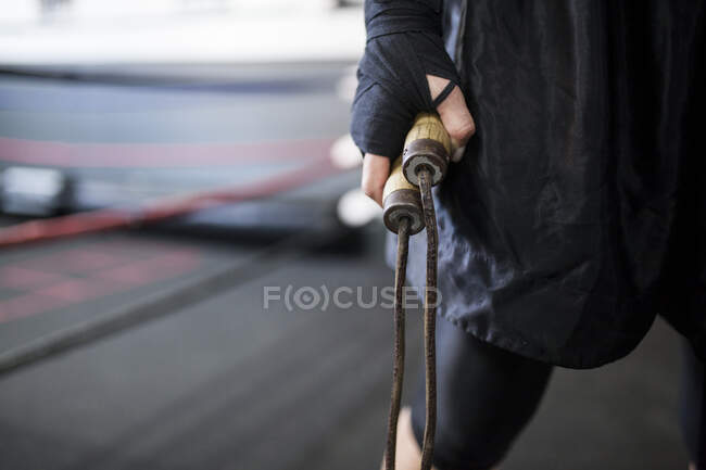 Muscular woman holding wooden jump rope — Stock Photo