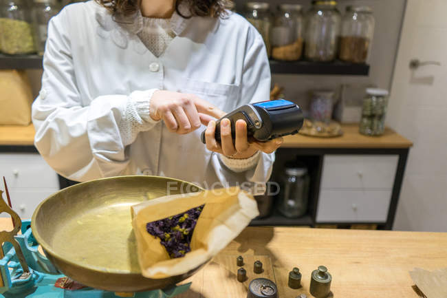 Shop assistant using terminal — Stock Photo