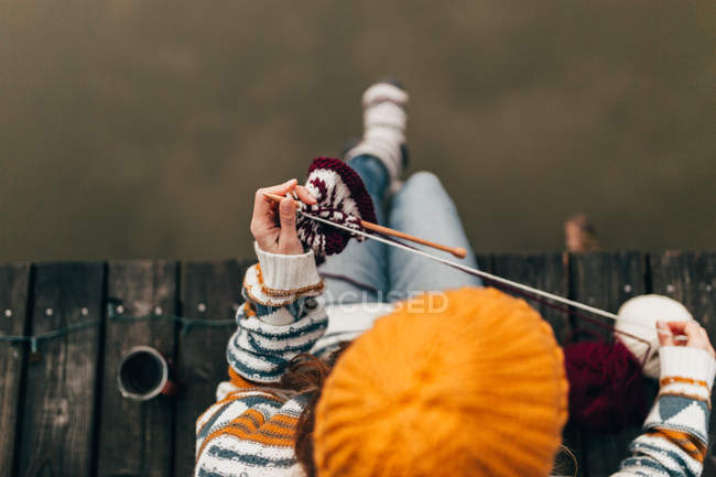 Жінка в'язала на дерев'яному ганку — стокове фото