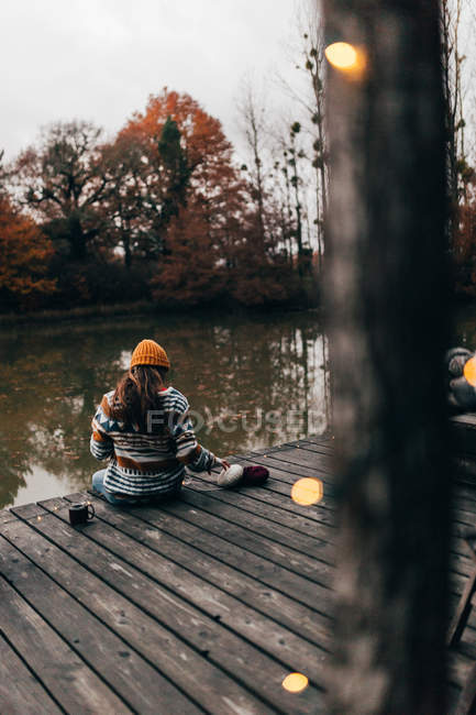 Женщина сидит и вяжет на пруду — стоковое фото