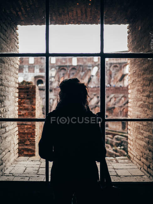 Person blickt aus Fenster auf Ruinen — Stockfoto
