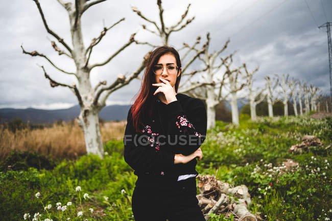 Dreaming woman standing in green field — Stock Photo