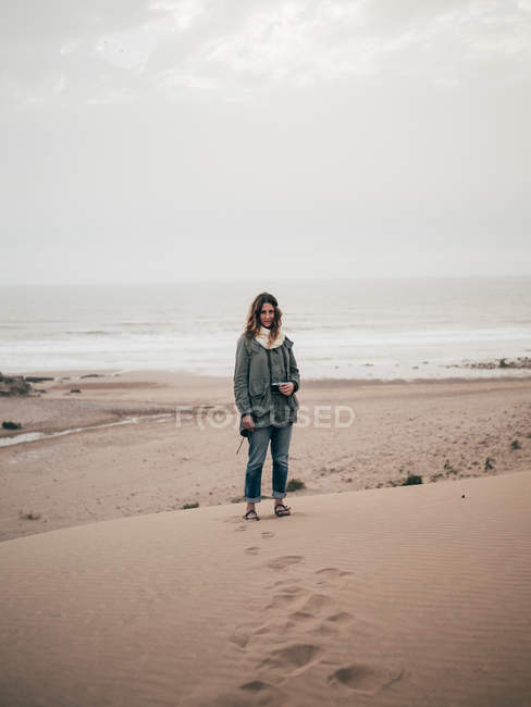 Femme debout sur la côte de l'océan — Photo de stock