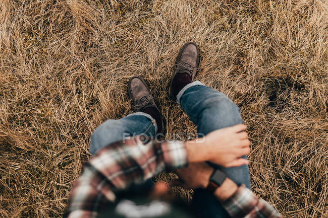 Man sitting on straw grass — Stock Photo