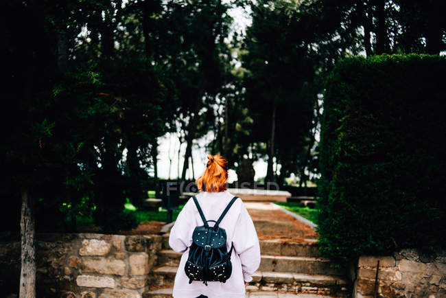 Жінка з рюкзаком, що йде в лісі — стокове фото