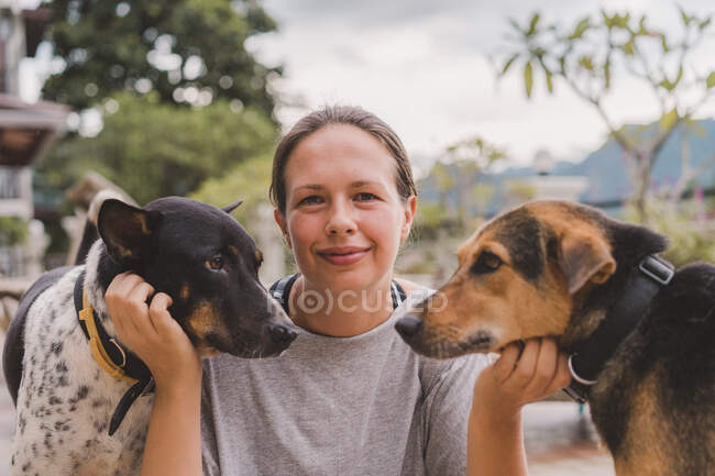 Женщина гладит собак на холме — стоковое фото