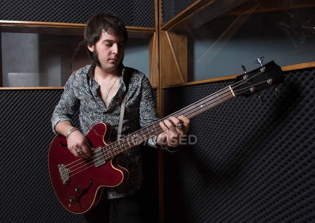 Man playing guitar in studio — Stock Photo