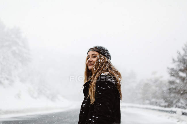 Frau steht auf schneebedeckter Straße — Stockfoto