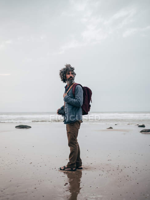 Homme debout à l'océan calme — Photo de stock