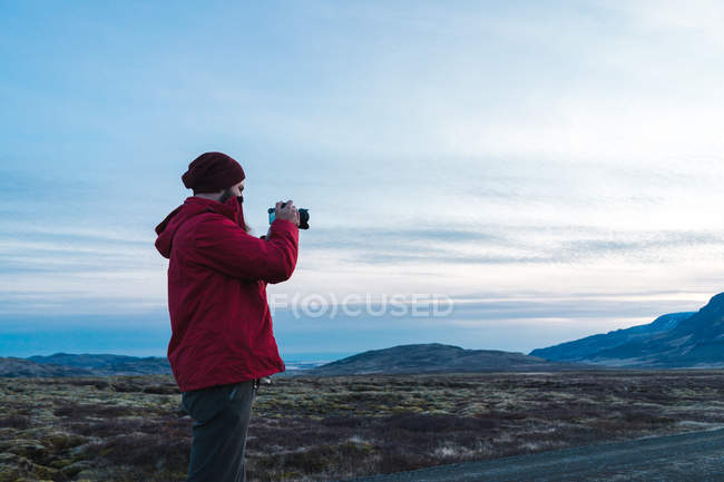 Homme prenant des photos du paysage islandais — Photo de stock