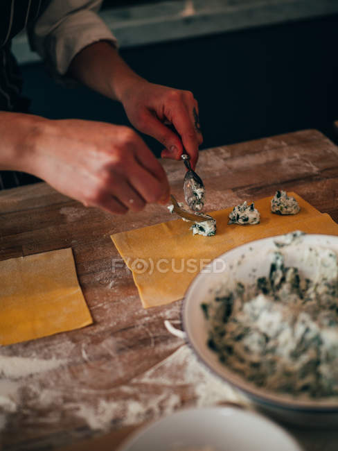 Mani che servono ripieno per ravioli — Foto stock