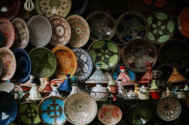 Stand con coloridos platos pintados tradicionales en la tienda en Marruecos. - foto de stock