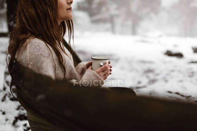 Woman sitting in hammock in winter — Stock Photo