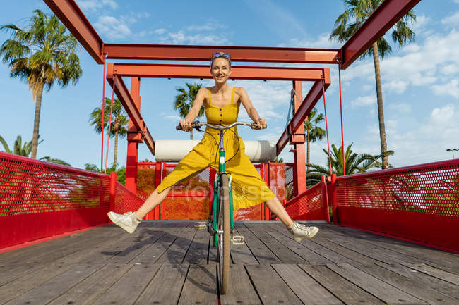 Mulher de vestido amarelo andar de bicicleta — Fotografia de Stock