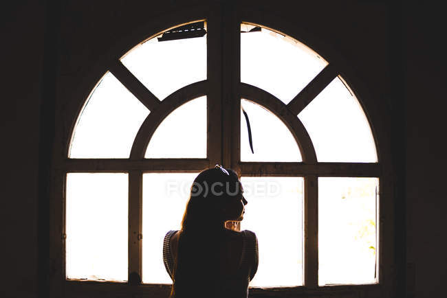 Femme debout à côté de la fenêtre — Photo de stock