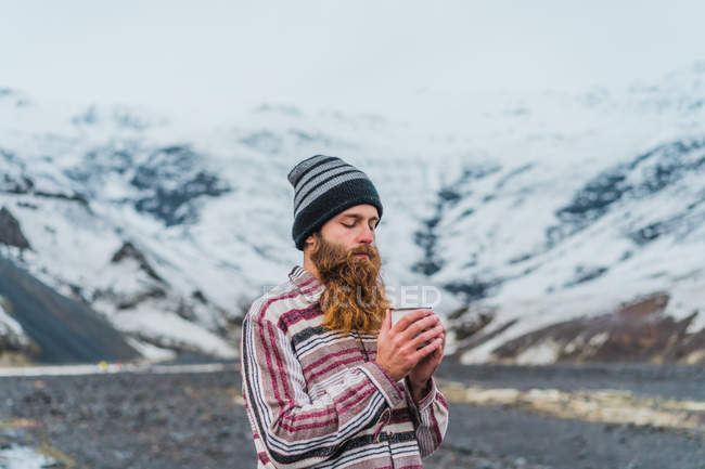 Man holding mug standing in nature — Stock Photo