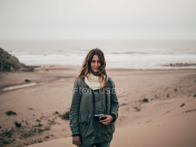 Жінка стоїть на узбережжі океану — стокове фото