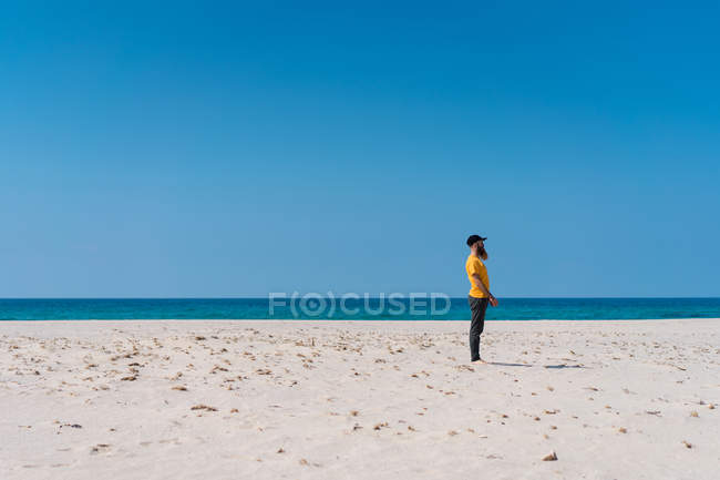 Uomo in piedi sulla spiaggia di sabbia — Foto stock