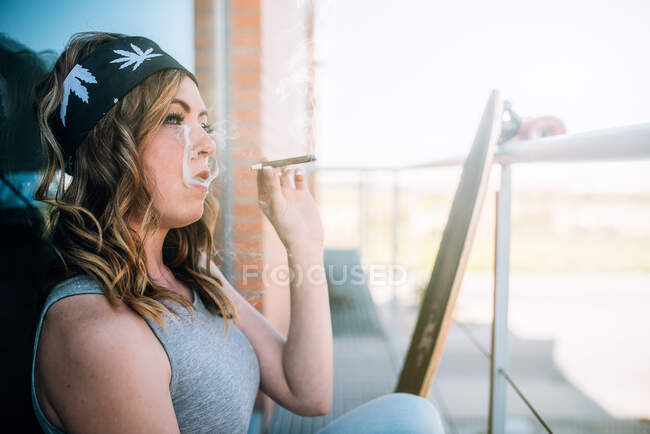 Jovem mulher fumando um charro cannabis — Fotografia de Stock