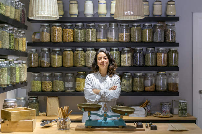 Woman with arms crossed in spice shop — Stock Photo