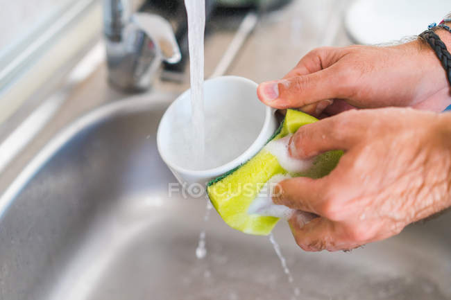 Руки миття чашки з губкою — стокове фото