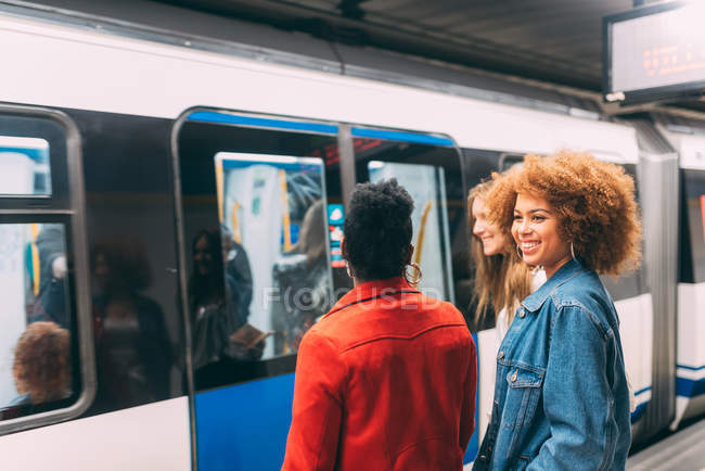 Jóvenes mujeres multirraciales esperando tren - foto de stock