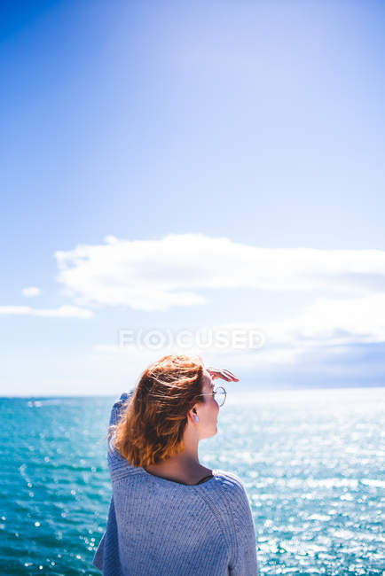 Mulher de pé no corrimão e olhando para o oceano — Fotografia de Stock